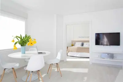 a white room with a table and chairs and a bed at Sitges Bellavista · Vistas Espectaculares del Mar in Sitges