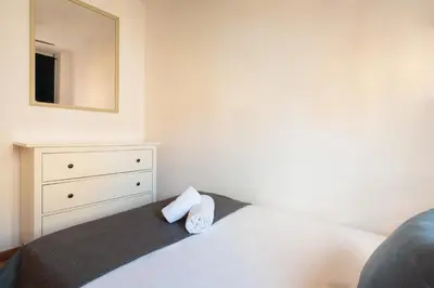 a bedroom with a bed with a dresser and a mirror at Mar Bella Beach Apartments in Barcelona