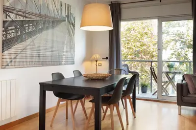 a dining room with a black table and chairs at Mar Bella Beach Apartments in Barcelona