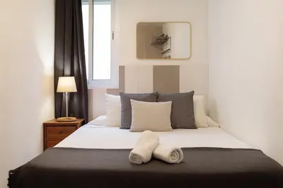 a bedroom with a bed with two towels on it at Portal Del Angel Barcelona Apartment in Barcelona