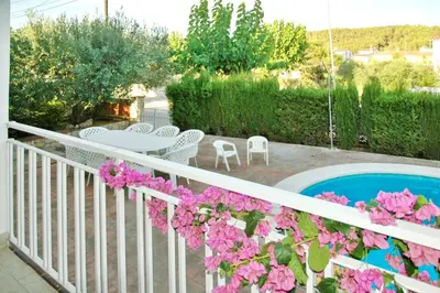 a balcony with pink flowers and a swimming pool at Spacious Apartment in Canyelles with Private Pool in Canyelles
