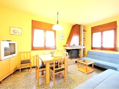 a living room with a blue couch and a table at Spacious Apartment in Canyelles with Private Pool in Canyelles