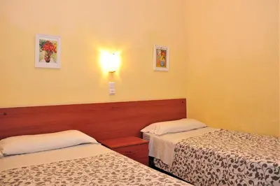 a room with two beds and a light on the wall at Hostal Bejar in Barcelona