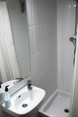 a bathroom with a sink and a mirror and a tub at Hostal Bejar in Barcelona