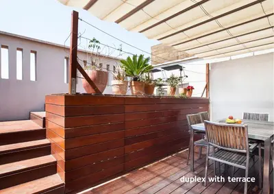 a balcony with a wooden wall with a table and chairs at Inside Barcelona Apartments Mercat in Barcelona