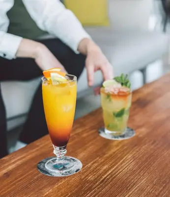 two cocktails sitting on a wooden table at Hotel Rec Barcelona - Adults Only in Barcelona