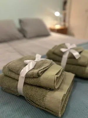 two towels with a bow on top of a bed at Beach flat with garden in Castelldefels