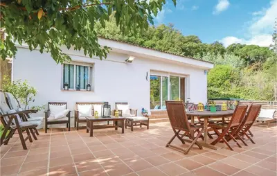 a patio with chairs and a table and a table and chairs at Nice Home In St Cebrià De Vallalta in Sant Cebrià de Vallalta