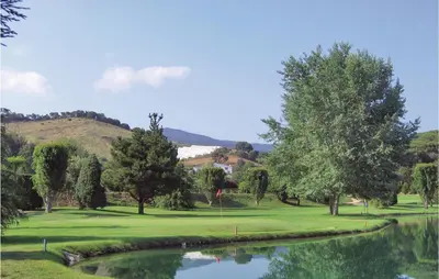 a view of a golf course with a pond at Nice Home In St Cebrià De Vallalta in Sant Cebrià de Vallalta