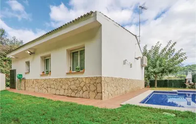 a house with a swimming pool in front of it at Nice Home In St Cebrià De Vallalta in Sant Cebrià de Vallalta