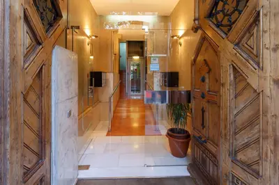 a hallway with wooden doors and a potted plant at Ciudad Condal Hostal - Paseo de Gracia in Barcelona