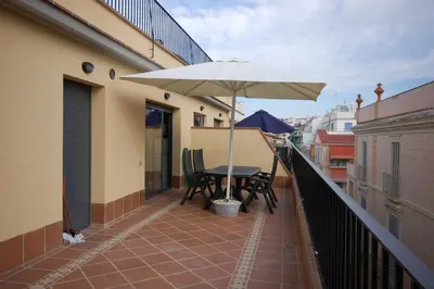 a balcony with a table and an umbrella at Sitges Apartment in Sitges