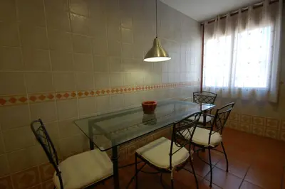 a room with a glass table and four chairs at Sitges Apartment in Sitges