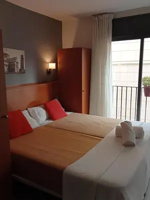 a hotel room with two beds and a window at Sitges Apartment in Sitges