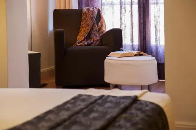 a living room with a black chair and a table at Hostal Goya in Barcelona
