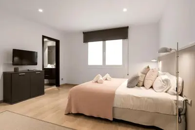 a bedroom with a large bed and a television at Fisa Rentals Gran Via Apartments in Barcelona