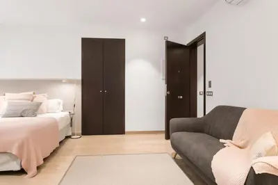 a living room with a bed and a couch at Fisa Rentals Gran Via Apartments in Barcelona