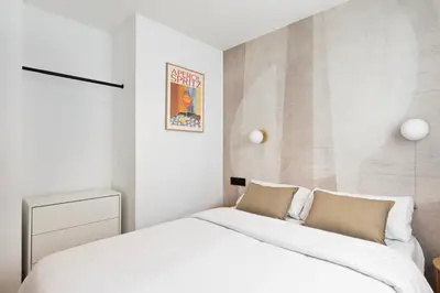 a bedroom with a large white bed with two pillows at Vibe Apartments by Olala Homes in Hospitalet de Llobregat