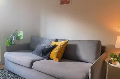 a couch with pillows on it in a living room at Vibe Apartments by Olala Homes in Hospitalet de Llobregat