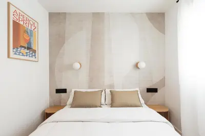 a bedroom with a bed with white sheets and pillows at Vibe Apartments by Olala Homes in Hospitalet de Llobregat