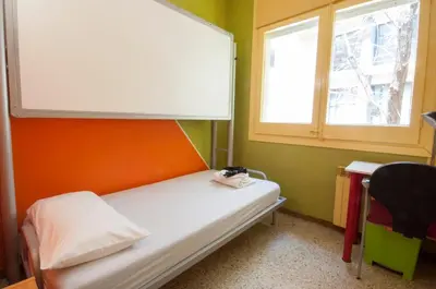 a small room with a bed and a window at Studio Hostel in Barcelona