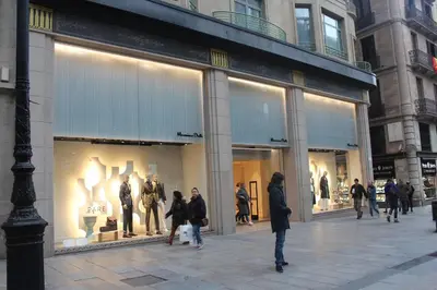 a group of people walking in front of a store window at Pensión Arosa in Barcelona