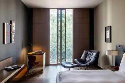 a bedroom with a bed and two chairs in front of a window at Alma Barcelona GL in Barcelona