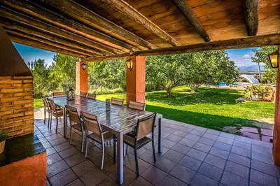 a wooden table and chairs on a patio at Catalunya Casas Country Chateau for 22 persons - close to Sitges! in Les Masuques