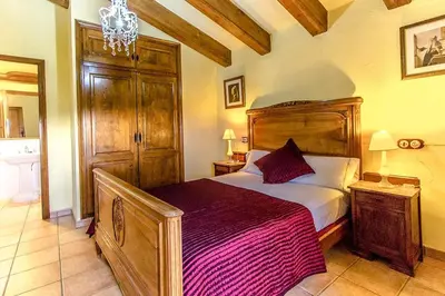 a bedroom with a bed and a chandelier at Catalunya Casas Country Chateau for 22 persons - close to Sitges! in Les Masuques