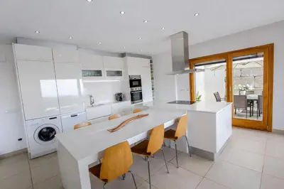 a kitchen with a large white island in a kitchen at Catalunya Casas Modern Magnificence , only a few km to the beach! in Sant Cebrià de Vallalta