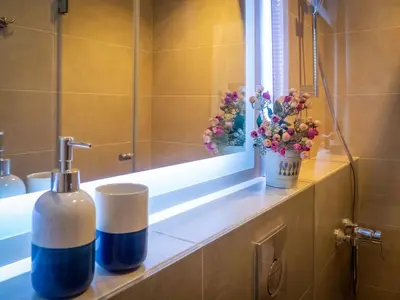 a bathroom with a sink and a window and flowers at Pension Ciudadela in Barcelona
