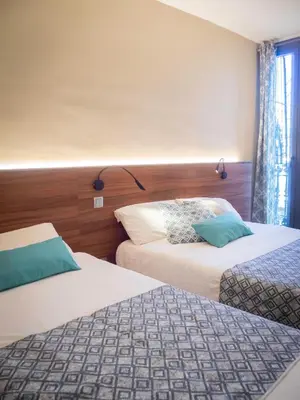 a hotel room with two beds and a window at Pension Ciudadela in Barcelona