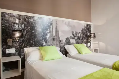 two beds in a room with a mural on the wall at Bcngotic in Barcelona