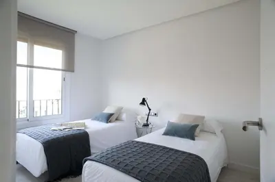 a bed with a lamp and a pillow on it at Eric Vökel Boutique Apartments - Gran Vía Suites in Barcelona