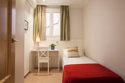 a small bedroom with a bed and a desk at BCNGOTIC 22 in Barcelona