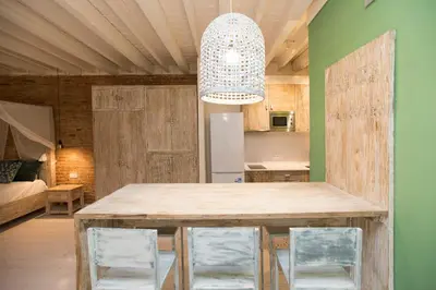 a kitchen with a large wooden table and chairs at La Bodega Suites in Hospitalet de Llobregat