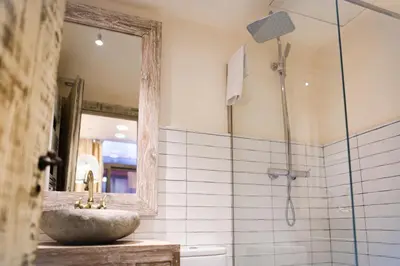 a bathroom with a sink and a shower with a mirror at La Bodega Suites in Hospitalet de Llobregat