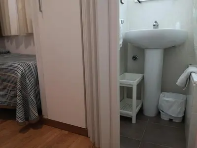 a bathroom with a sink next to a bed at Hostal Lesseps in Barcelona