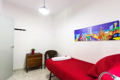 a bedroom with a red bed and a painting on the wall at Charm Apartment Sagrada Familia in Barcelona