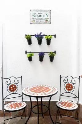 two chairs and a table with potted plants on a wall at KeyFamily Lovely Villa in Barcelona