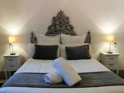 a bedroom with two beds with two lamps on either side at Hotel El Xalet in Sitges