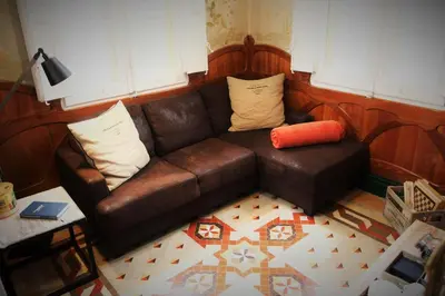 a brown leather couch in a living room at Hotel El Xalet in Sitges