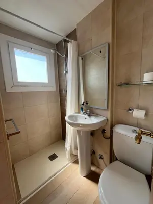 a bathroom with a sink and a toilet and a window at Hostal Casa Torrent in Canet de Mar