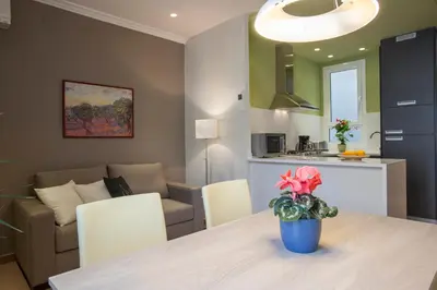 a kitchen and living room with a table with a flower in a blue pot at BCNGOTIC43 in Barcelona