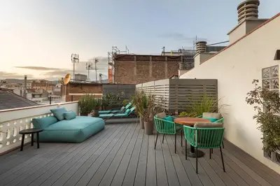 a rooftop deck with a couch and a table and chairs at Be Mate Paseo de Gracia in Barcelona