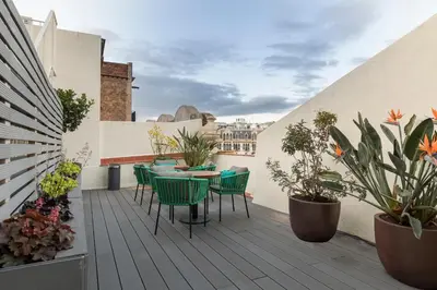 a rooftop patio with tables and chairs and plants at Be Mate Paseo de Gracia in Barcelona