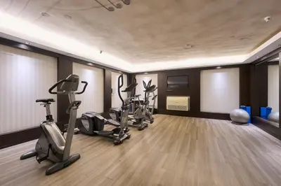 a gym with treadmills and exercise bikes in a room at Catalonia Rigoletto in Barcelona
