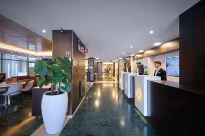 a lobby of a restaurant with a woman standing at a counter at Catalonia Rigoletto in Barcelona