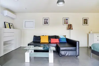 a living room with a black couch with colorful pillows at Jewel Home in Sant Pere de Ribes