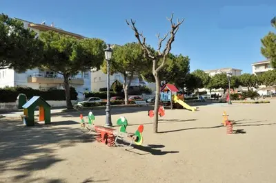 a playground with colorful play equipment in a park at Mar De Cunit in Cunit